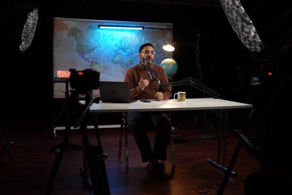 Wide shot of podcast recording studio with multiple cameras and lighting rigs